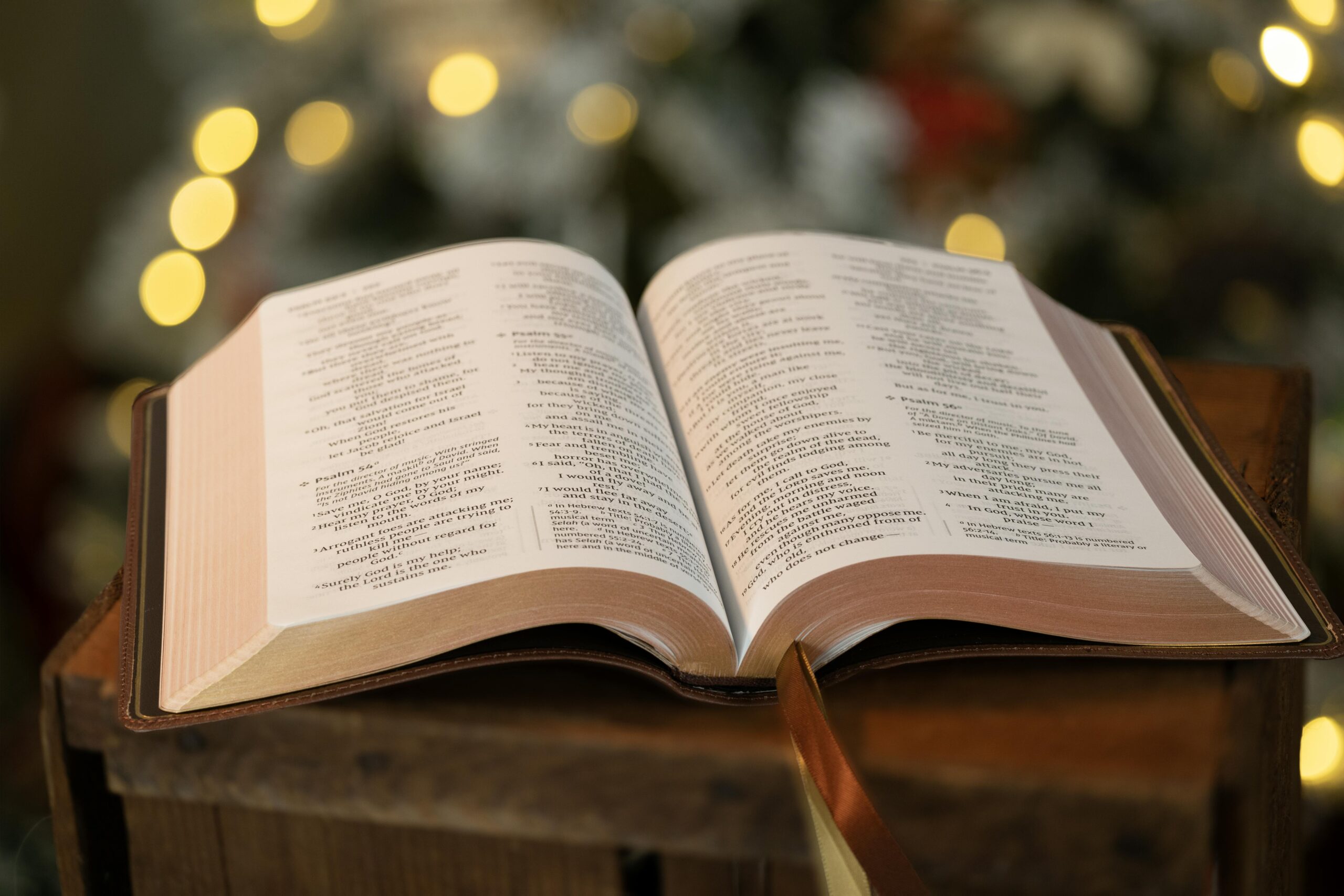 Luz entrando por una ventana sobre una Biblia abierta y una libreta con pluma